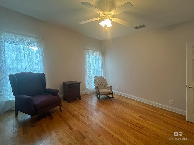 sitting room with ceiling fan and hardwood / wood-style floors