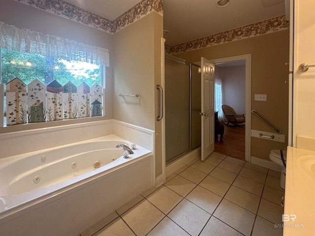 bathroom with tile floors, a wealth of natural light, toilet, and independent shower and bath