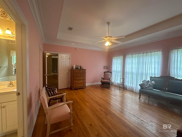 interior space with wood-type flooring, plenty of natural light, ceiling fan, and a raised ceiling