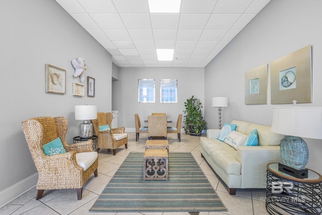 living room featuring light tile patterned flooring and a paneled ceiling