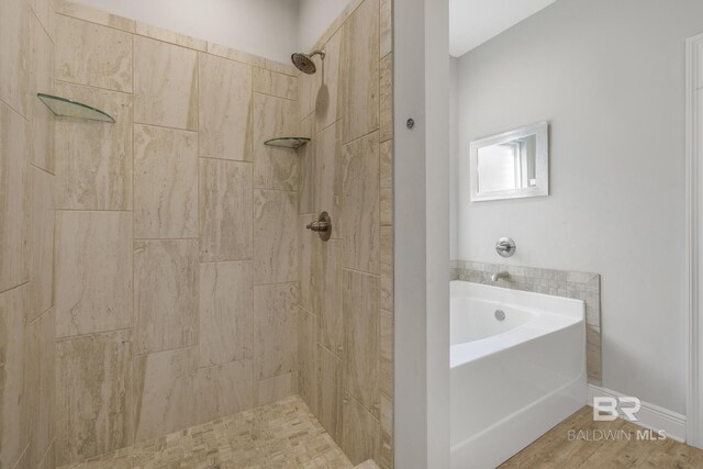 bathroom featuring tiled shower, a garden tub, and wood finished floors