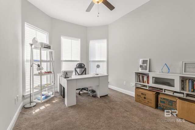 home office featuring carpet floors, a ceiling fan, and baseboards