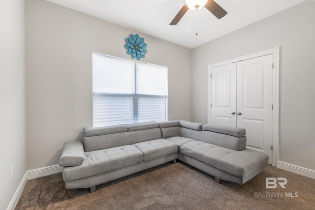 carpeted living room featuring baseboards and a ceiling fan