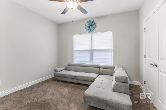 living area featuring baseboards, carpet flooring, and ceiling fan