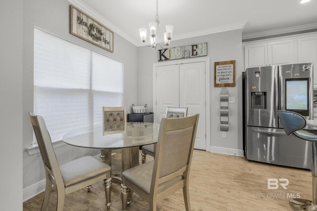 dining area featuring baseboards, a notable chandelier, ornamental molding, and light wood-style floors