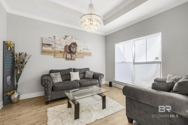 living room featuring baseboards, a raised ceiling, wood finished floors, and a notable chandelier