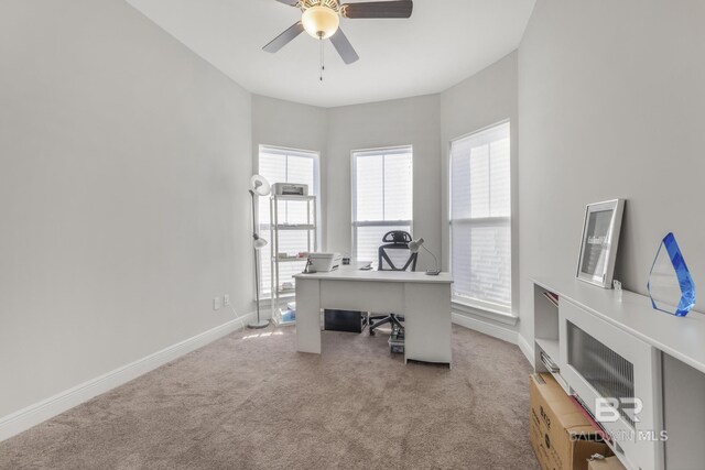 office area featuring baseboards, ceiling fan, light carpet, and a healthy amount of sunlight