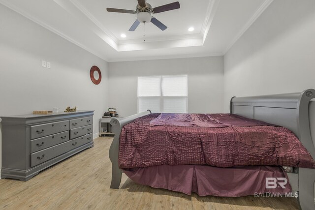 bedroom featuring ceiling fan, wood finished floors, ornamental molding, a tray ceiling, and recessed lighting