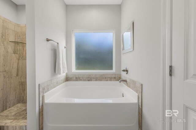 full bath featuring a tile shower and a garden tub