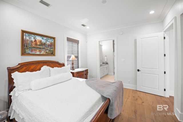 bedroom with crown molding, visible vents, and light wood-style floors