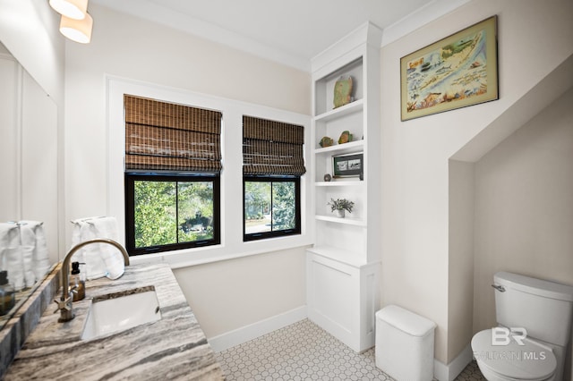 bathroom featuring toilet, vanity, and baseboards