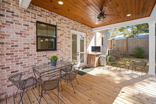 wooden deck with ceiling fan, outdoor dining space, and fence