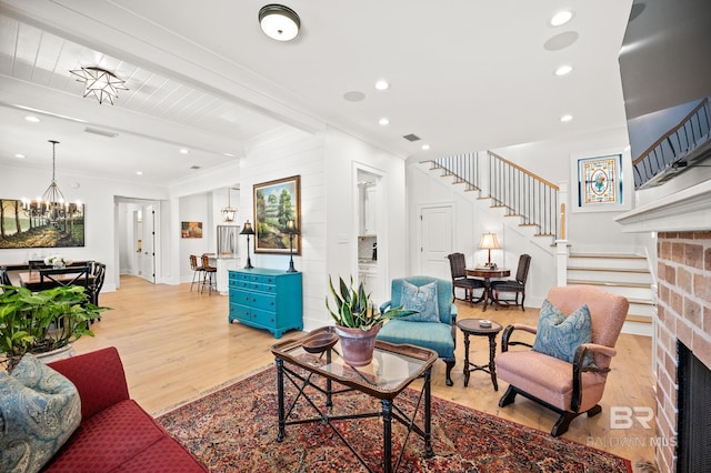 living room featuring light wood-style flooring, beamed ceiling, stairway, and ornamental molding