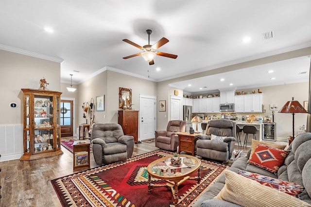 living room featuring ceiling fan, hardwood / wood-style flooring, and crown molding