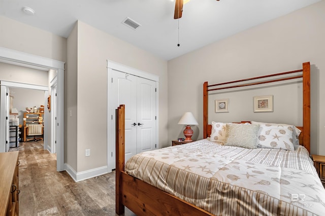 bedroom featuring ceiling fan, light hardwood / wood-style flooring, and a closet