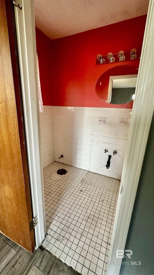 bathroom featuring a textured ceiling and wood finished floors