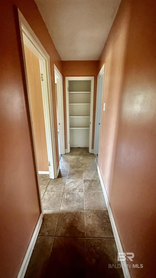 hallway featuring baseboards and built in features