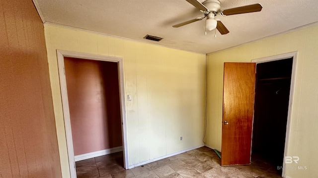 unfurnished bedroom with a ceiling fan, visible vents, a textured ceiling, and ornamental molding