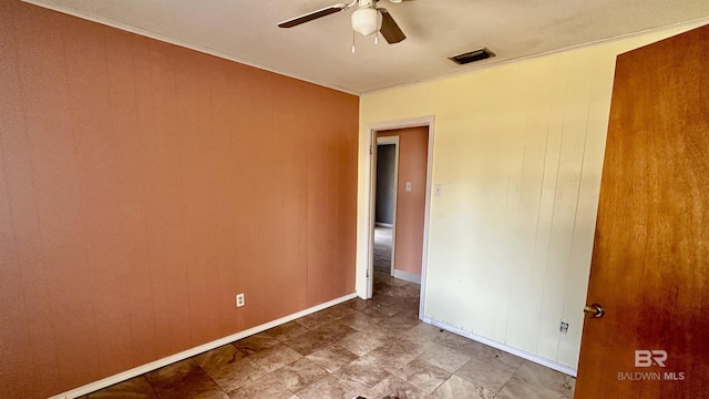 spare room featuring visible vents, ceiling fan, and baseboards