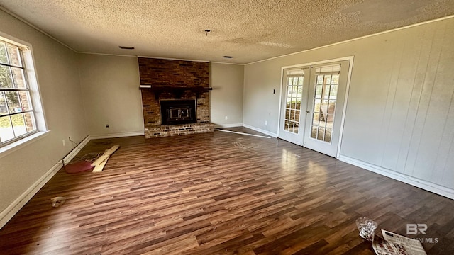 unfurnished living room with a healthy amount of sunlight, dark wood-type flooring, and french doors