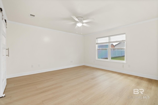 4310 Lauder Ln, Orange Beach, AL 36561 - spare room featuring a ceiling fan, ornamental molding, a barn door, and light wood finished floors