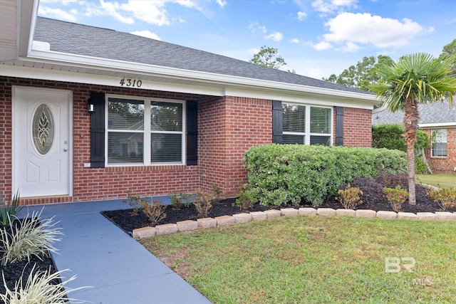 4310 Lauder Ln, Orange Beach, AL 36561 - entrance to property featuring a yard, brick siding, and roof with shingles
