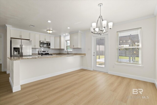 4310 Lauder Ln, Orange Beach, AL 36561 - kitchen featuring light wood finished floors, white cabinetry, stainless steel appliances, decorative backsplash, and an inviting chandelier