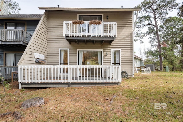 back of property featuring a yard and a balcony