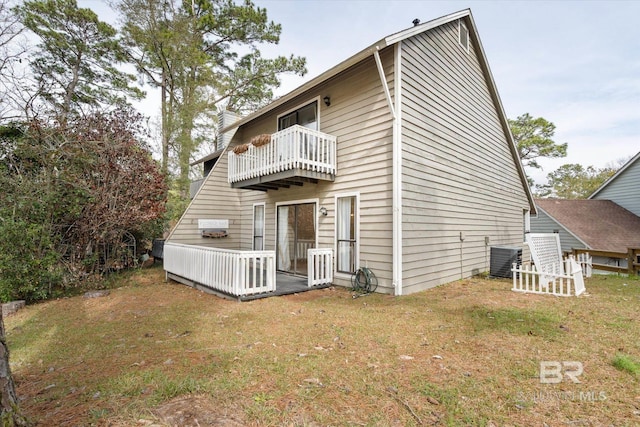 back of house featuring a lawn, a chimney, a balcony, and central air condition unit