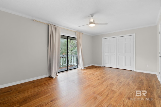 unfurnished bedroom with access to exterior, crown molding, and wood finished floors