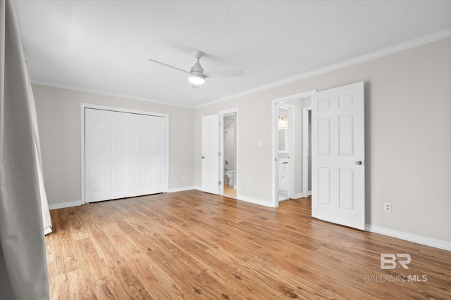 unfurnished bedroom with light wood-style floors, baseboards, ornamental molding, and a closet