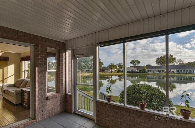 9577 Villas Dr, Foley, AL 36535 - sunroom / solarium with tile patterned floors, a water view, brick wall, and a wealth of natural light