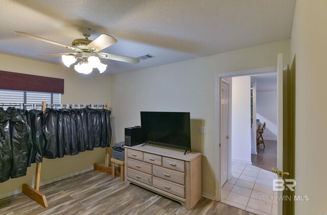 9577 Villas Dr, Foley, AL 36535 - bedroom with baseboards, a textured ceiling, visible vents, light wood-style flooring, and ceiling fan