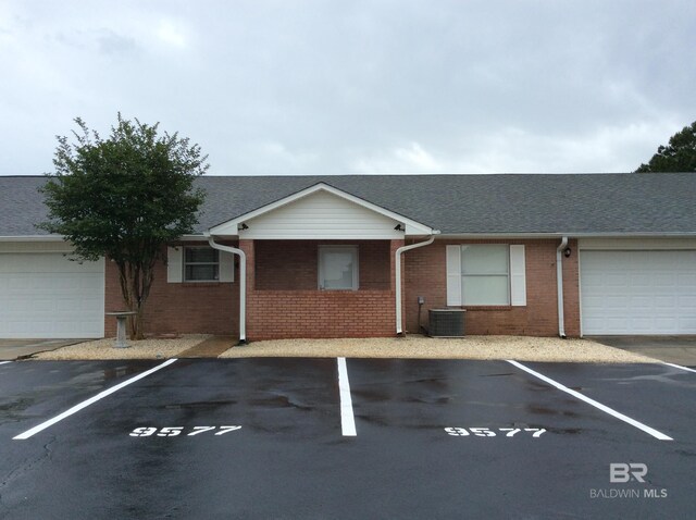 9577 Villas Dr, Foley, AL 36535 - view of front of property with brick siding, uncovered parking, central AC unit, and roof with shingles