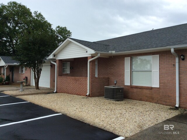 9577 Villas Dr, Foley, AL 36535 - view of side of home featuring brick siding, central air condition unit, and uncovered parking