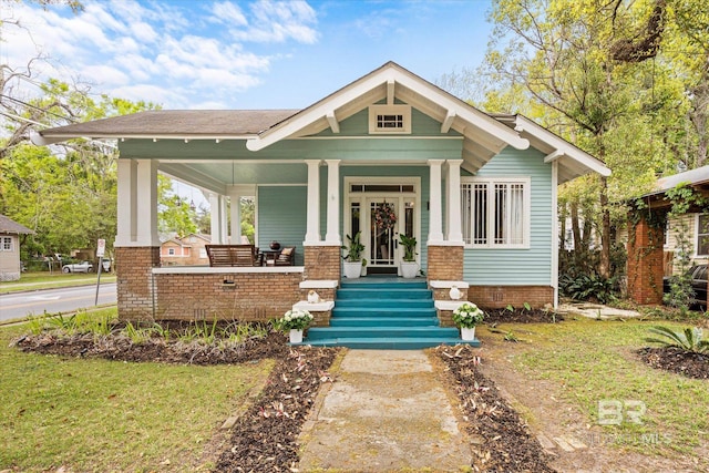 view of front of home with a front yard and a porch