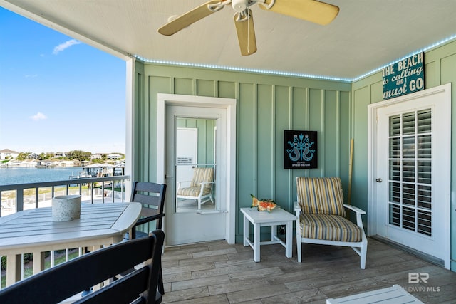 balcony featuring a water view and ceiling fan