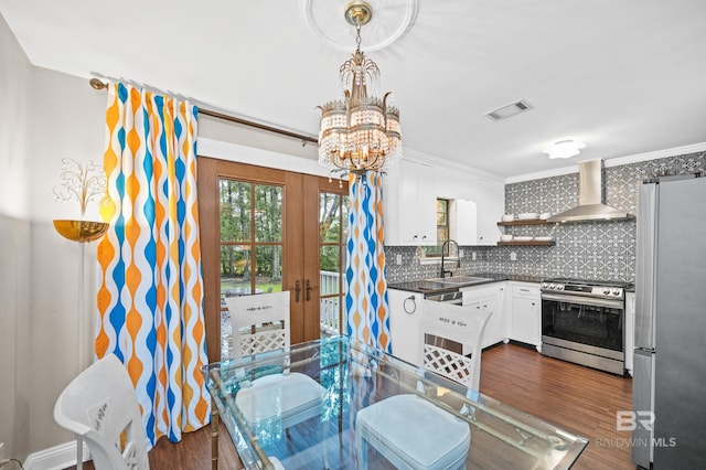 dining room with an inviting chandelier, sink, french doors, dark hardwood / wood-style floors, and ornamental molding