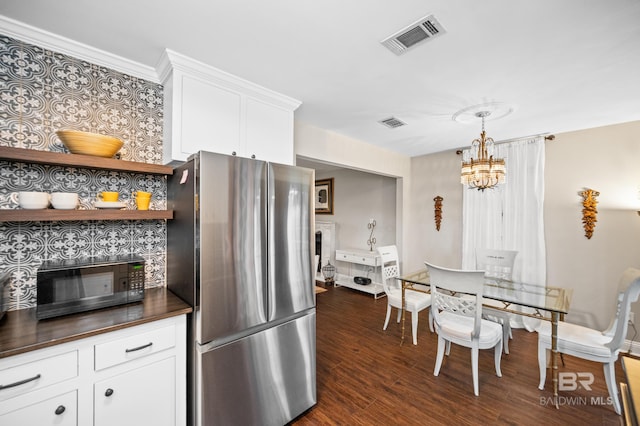 kitchen featuring decorative light fixtures, dark hardwood / wood-style flooring, white cabinets, an inviting chandelier, and stainless steel refrigerator