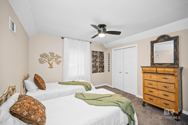 carpeted bedroom featuring lofted ceiling, a textured ceiling, a closet, and ceiling fan