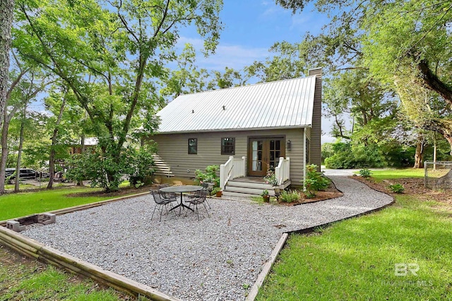 rear view of property with a patio, a yard, and french doors