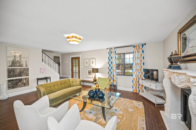 living room featuring dark wood-type flooring and a premium fireplace