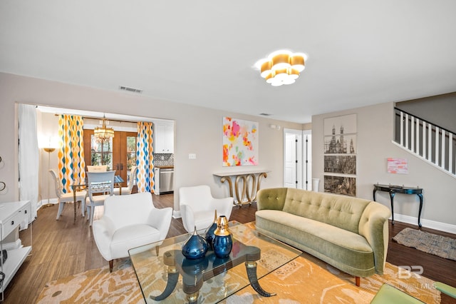 living room featuring a chandelier and light wood-type flooring