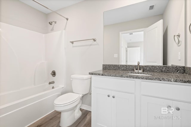 full bathroom featuring vanity, hardwood / wood-style floors, toilet, and shower / bathtub combination