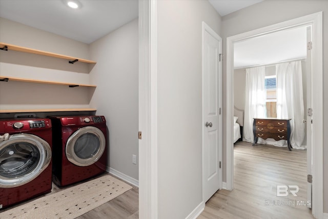 laundry area featuring separate washer and dryer and light hardwood / wood-style floors