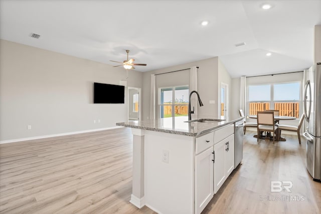 kitchen with a kitchen island with sink, sink, white cabinetry, light hardwood / wood-style flooring, and stainless steel appliances