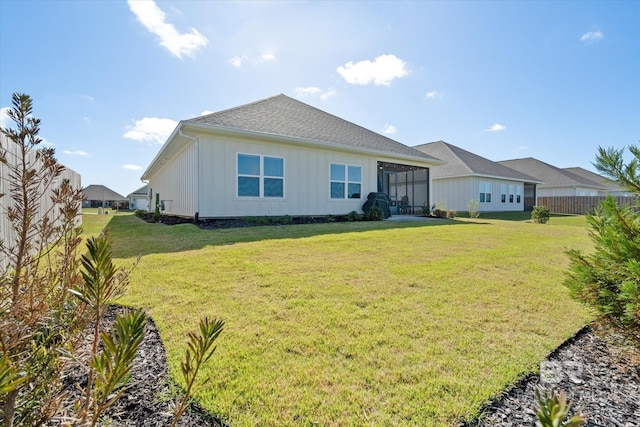 4299 Montague Dr, Gulf Shores, AL 36542 - rear view of property with board and batten siding, a lawn, and a sunroom