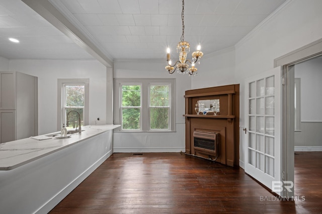 unfurnished dining area featuring crown molding, an inviting chandelier, heating unit, and dark wood finished floors