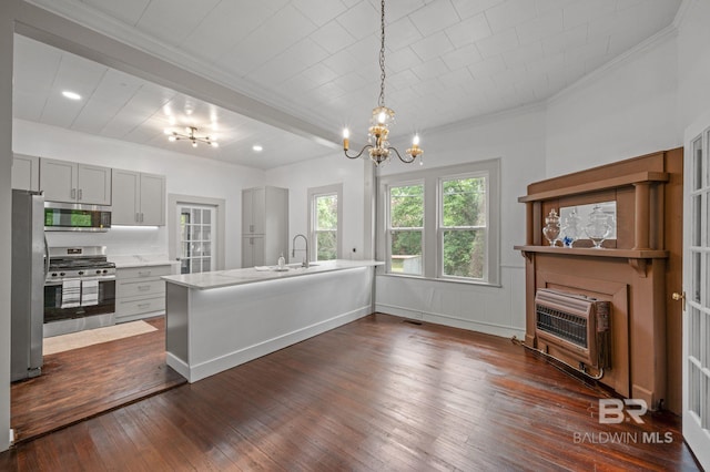 kitchen featuring ornamental molding, heating unit, gray cabinets, a sink, and stainless steel appliances