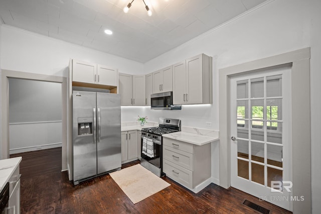 kitchen featuring visible vents, ornamental molding, dark wood finished floors, and appliances with stainless steel finishes